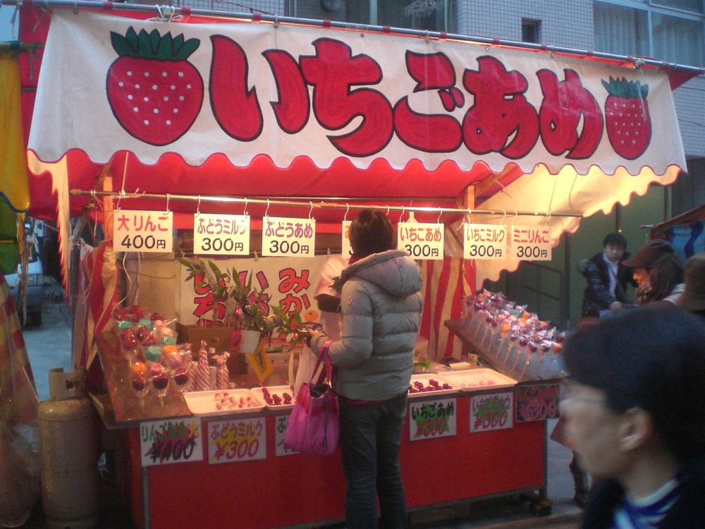 Un vendeur de pommes d'amour et d'autres fruits enrobés de sucre