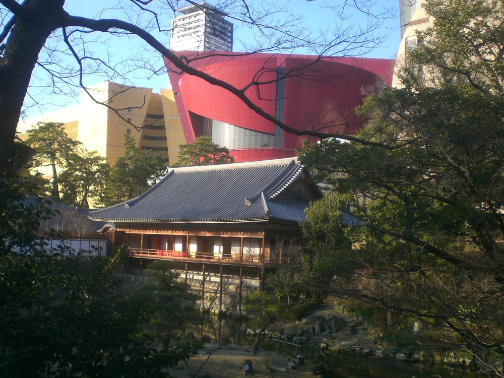 On distingue d'ailleurs le centre commercial aux couleurs criardes juste derrière la maison traditionnelle japonaise plantée au milieu du jardin du château