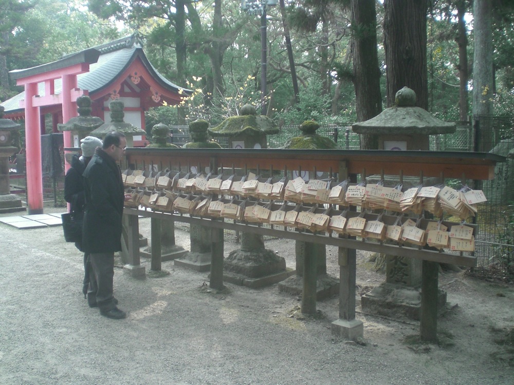 Les gens achètent puis accrochent ici des voeux imprimés sur des planchettes de bois
