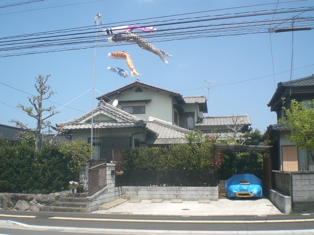 Des poissons volent dans le ciel car c'est bientôt la fête des garçons (début mai). ALors les familles qui ont des jeunes garçons en accrochent à leurs maisons
