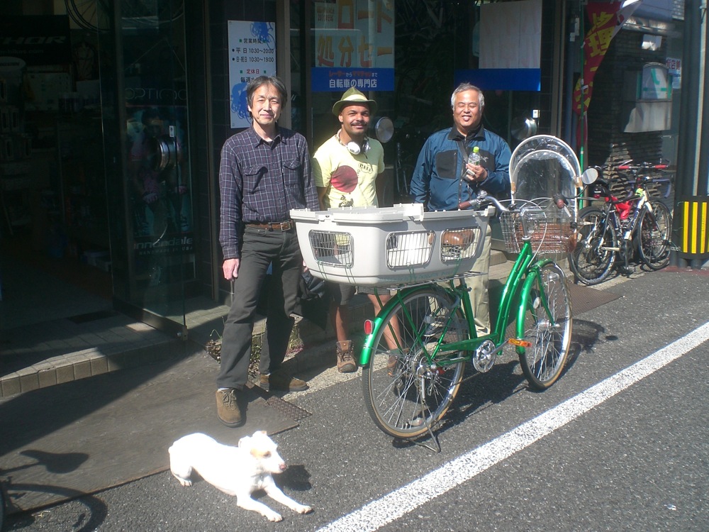 Kitakyushu: nous arrivons en avance et nous procédons à la 1ère réparation de vélo du voyage: François a de nouveau perdu beaucoup de rayons à l'arrière (du au chargement!) et sa roue est donc voilée. Photo avec le réparateur (à gauche) et son voisin (à droite) qui nous a offert à boire pendant la réparation!