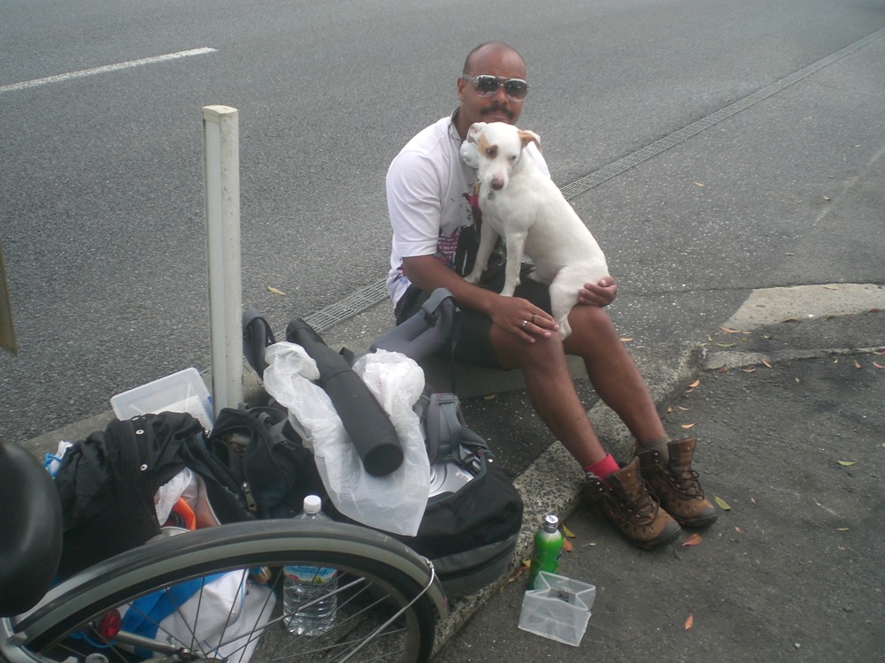 Notre réparation maison à base de carton et de scotch sur le pneu arrière aura tenu environ 2km! Nous avons parcouru le reste en poussant le vélo jusqu'à un réparateur! Pendant la réparation, nous faisons une petite pause... avec tous mes bagages à terre. 