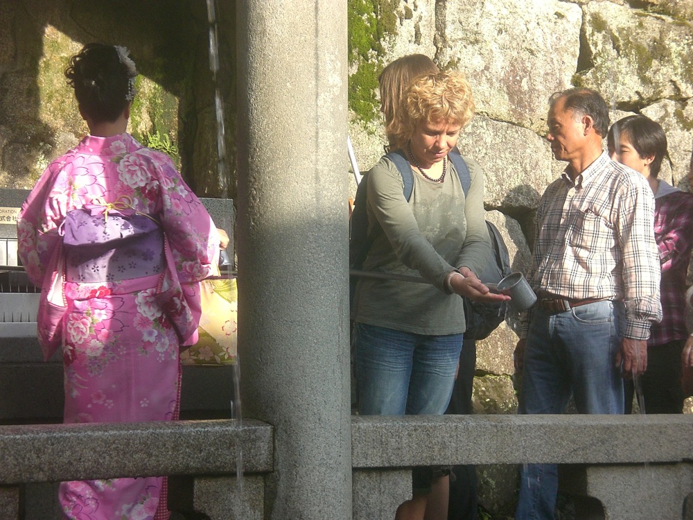 On récupère l'eau qui coule avec la longue louche, on se lave les mains