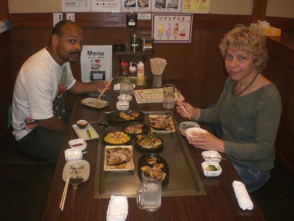 Dîner à base de teppanyaki: plats cuits sur une plaque chaude et servis sur la plaque chaude au milieu de notre table: aubergines, patates des montagne, maïs, gyozas, etc