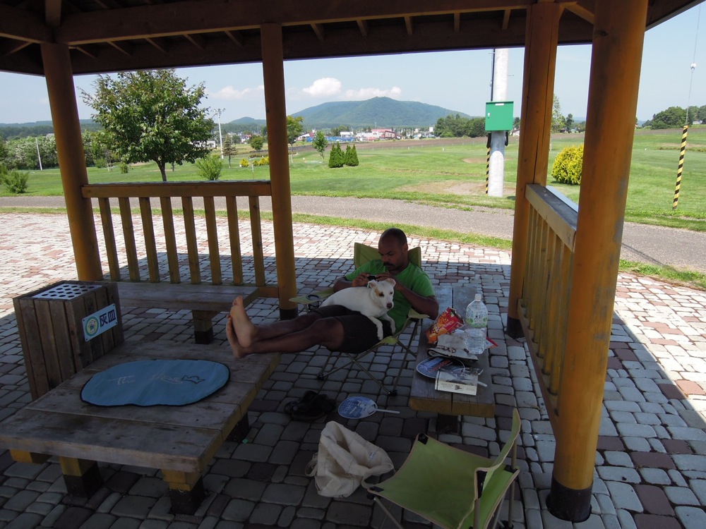 Camping Nauman: à l'abri de la chaleur sous ce gazebo... Carlo semble ko et préfère les jambes de son papa à son tapis royalement placé sur la table centrale!